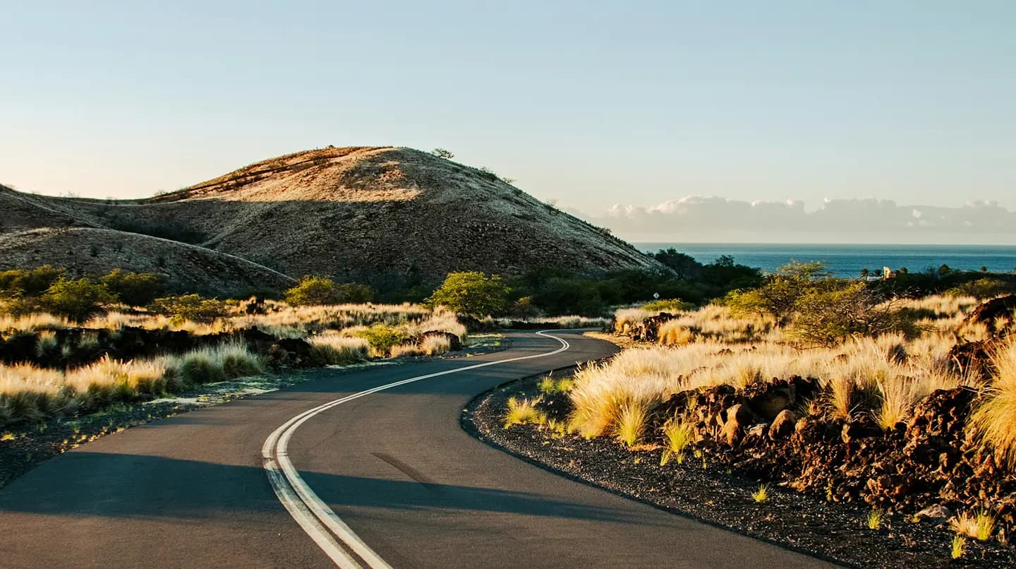 A scenic road winding through grassland hills